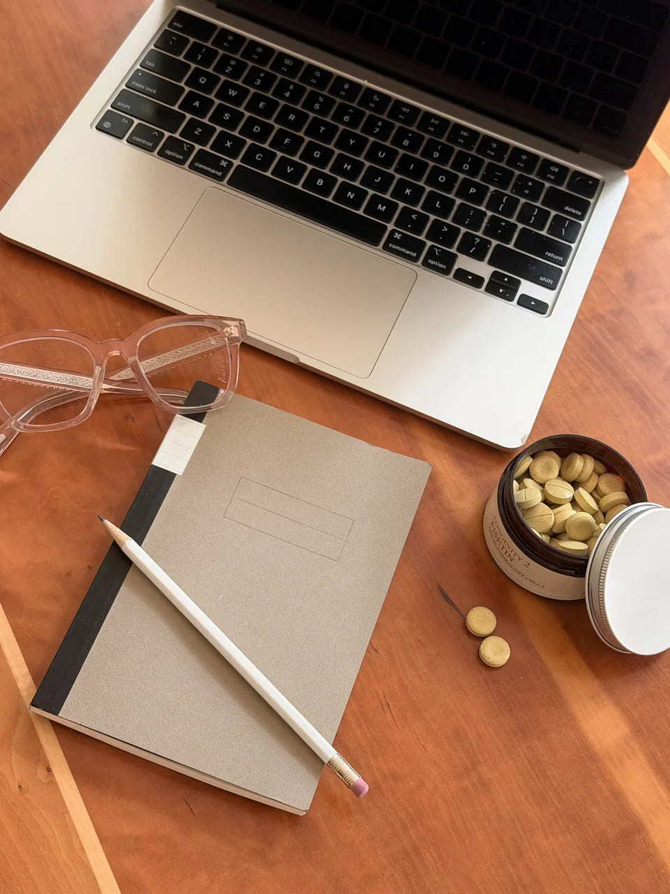 Research notebook, tea, and a small vial of powdered NMN
